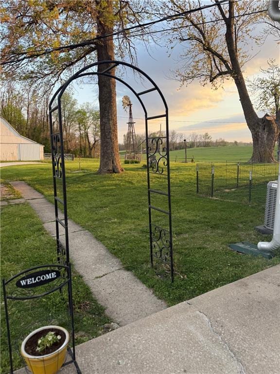 view of community with a lawn and fence
