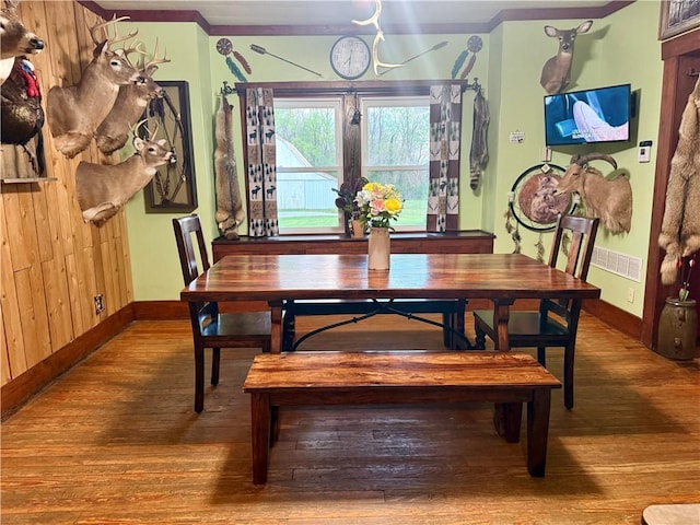 dining area featuring crown molding, wood finished floors, and baseboards