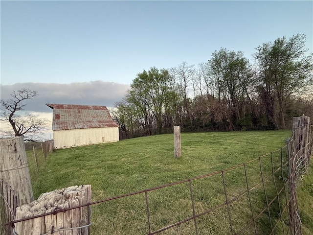 view of yard featuring a barn, fence, and an outbuilding