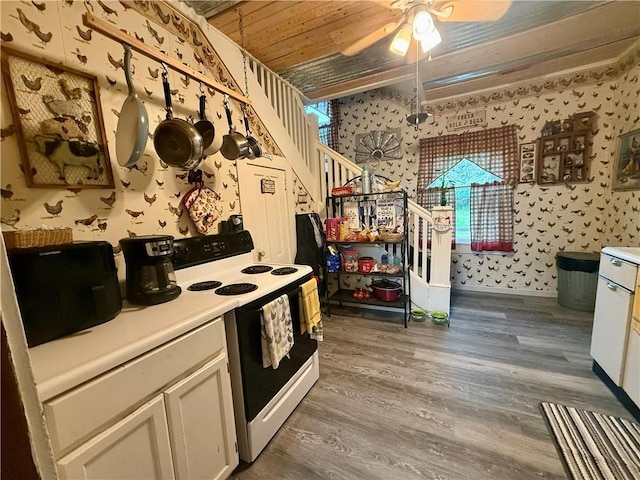 kitchen with a ceiling fan, wallpapered walls, wood finished floors, and electric range