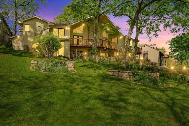 back of house at dusk with a yard