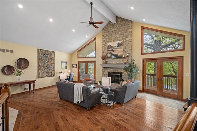 living room with french doors, high vaulted ceiling, ceiling fan, a stone fireplace, and healthy amount of natural light