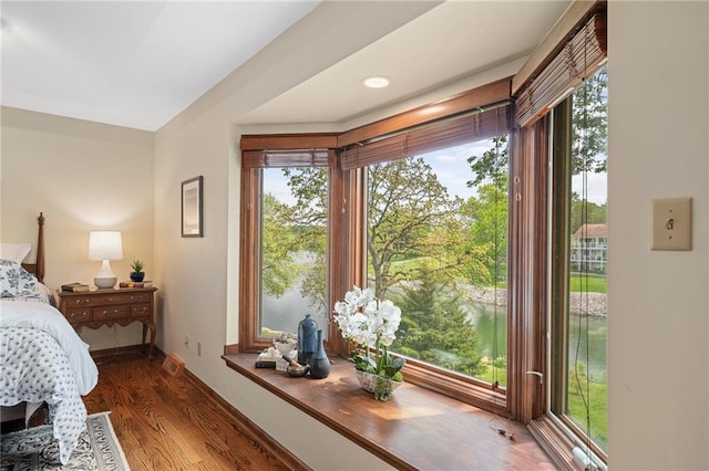 bedroom featuring wood finished floors, access to exterior, and baseboards
