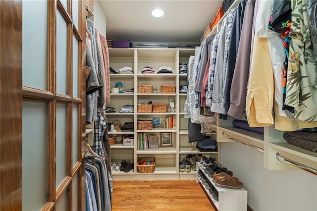 walk in closet with wood finished floors