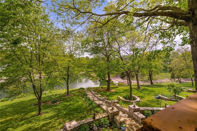 surrounding community featuring a water view and a lawn