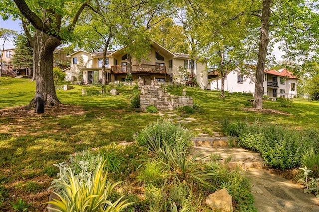 view of grassy yard featuring stairs and a deck