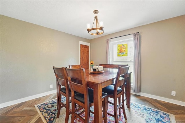 dining room featuring an inviting chandelier and baseboards