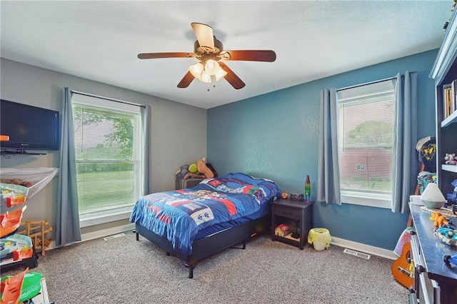 bedroom with ceiling fan, visible vents, baseboards, and carpet