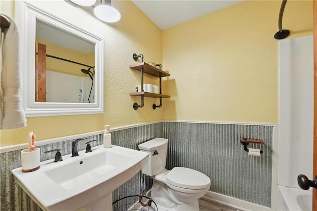 full bathroom with walk in shower, wainscoting, a sink, toilet, and a tub to relax in
