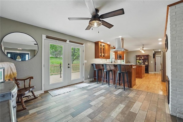 kitchen with brown cabinets, a peninsula, stainless steel appliances, and a kitchen bar