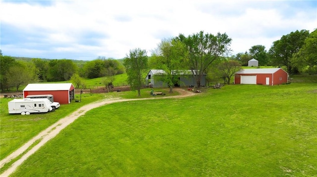 view of yard with driveway, an outbuilding, and a garage