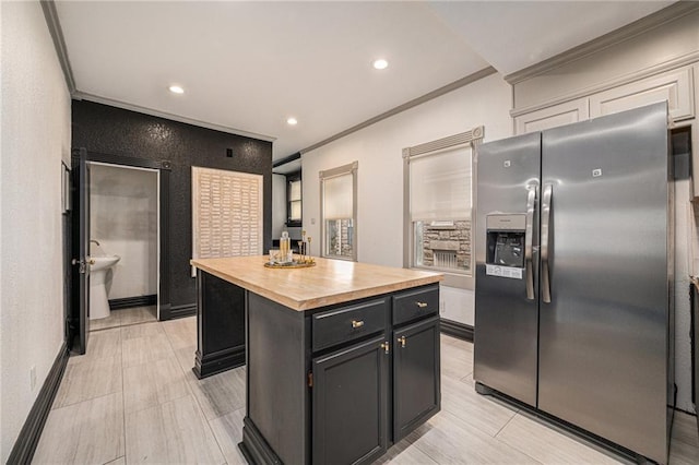525 W 38th St, Kansas City, MO 64111 - kitchen featuring stainless steel refrigerator with ice dispenser, butcher block counters, a kitchen island, recessed lighting, and ornamental molding
