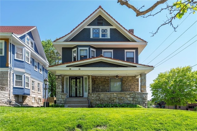 525 W 38th St, Kansas City, MO 64111 - american foursquare style home with stone siding, covered porch, a front lawn, and a chimney