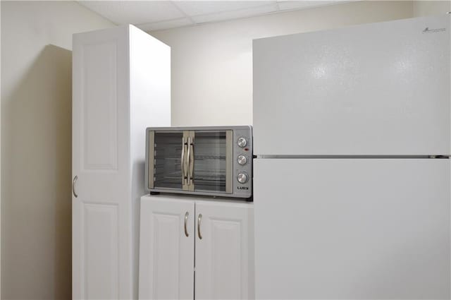 464 W 104th St Unit A, Kansas City, MO 64114 - details with stainless steel microwave, a drop ceiling, and freestanding refrigerator