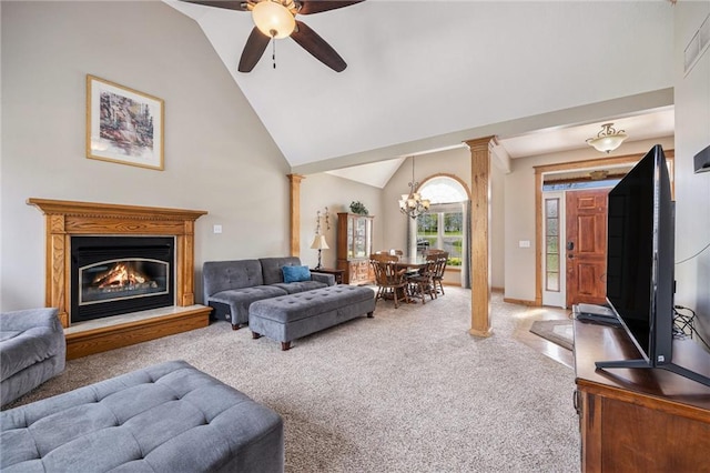 carpeted living room with high vaulted ceiling, a glass covered fireplace, ornate columns, and ceiling fan with notable chandelier