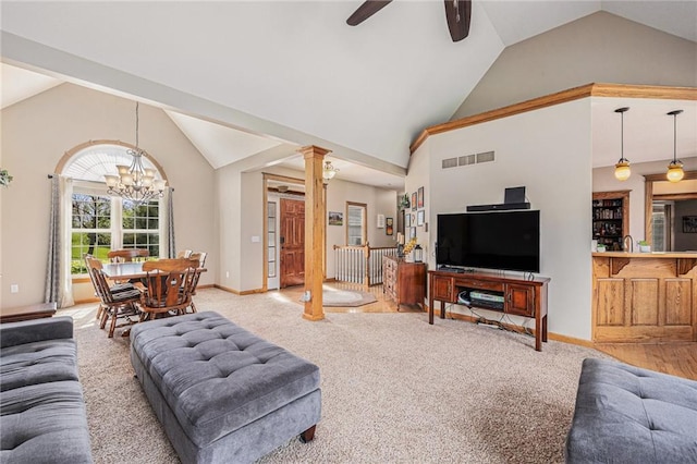 living room with ceiling fan with notable chandelier, decorative columns, visible vents, and light colored carpet