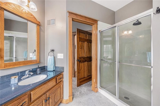 bathroom with visible vents, vanity, and a stall shower
