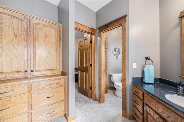 full bath with tile patterned flooring, toilet, vanity, and baseboards