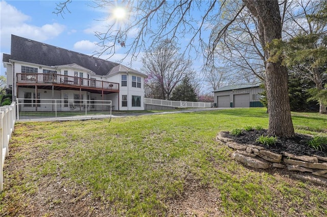 view of yard featuring a wooden deck, an outdoor structure, a garage, and fence