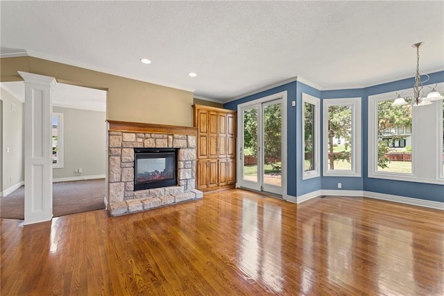 5108 W 150th St, Leawood, KS 66224 - unfurnished living room featuring wood finished floors, a fireplace, crown molding, a chandelier, and a textured ceiling