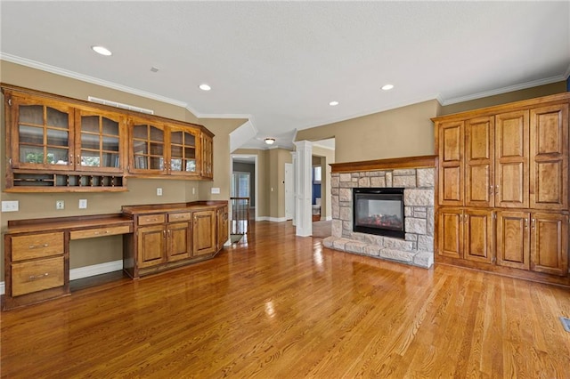 5108 W 150th St, Leawood, KS 66224 - kitchen with brown cabinetry, light wood-style flooring, glass insert cabinets, built in desk, and recessed lighting