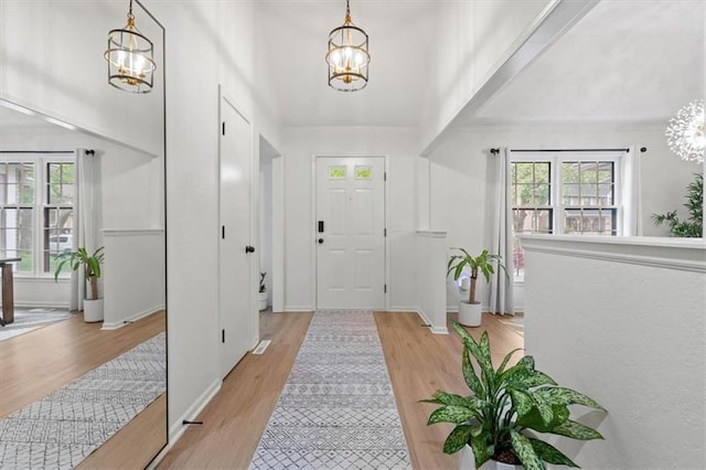 entryway featuring light wood-style floors and a chandelier