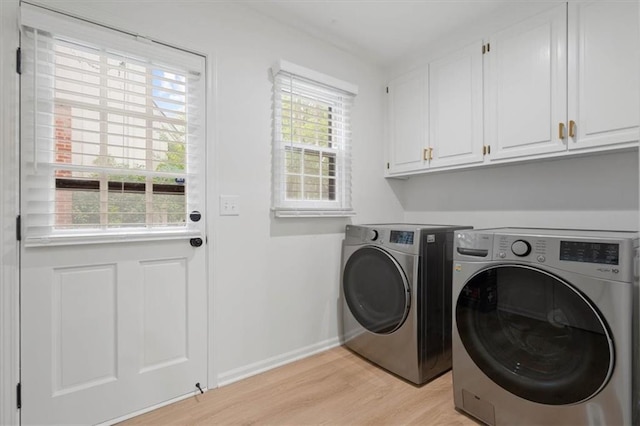 laundry room featuring cabinet space, separate washer and dryer, baseboards, and light wood-type flooring