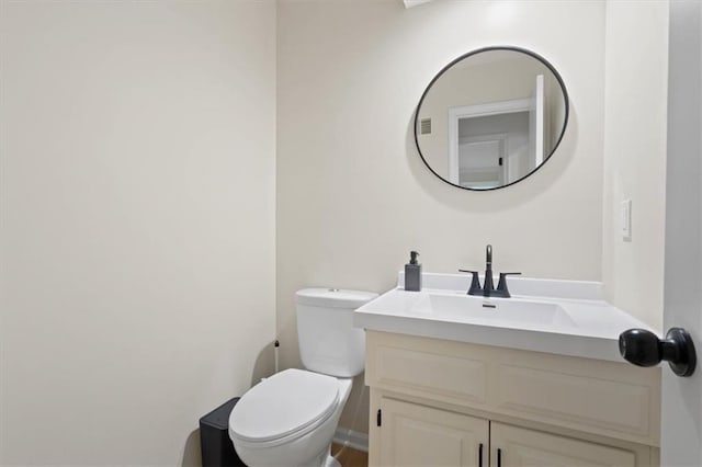 half bathroom with vanity and toilet