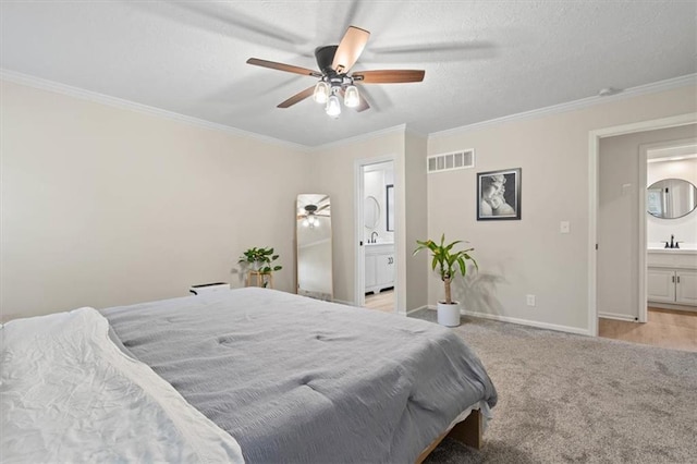 bedroom with visible vents, a sink, connected bathroom, and crown molding