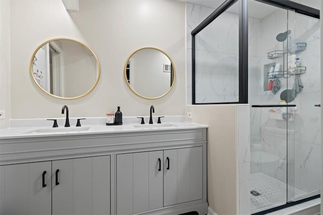 bathroom with double vanity, a sink, and a marble finish shower