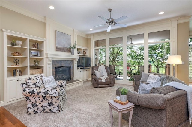 living room featuring a ceiling fan, crown molding, a high end fireplace, built in features, and recessed lighting
