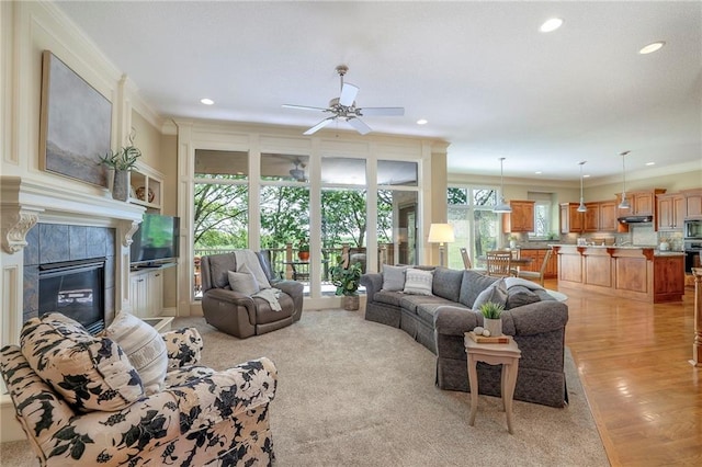 living area with ceiling fan, ornamental molding, and recessed lighting