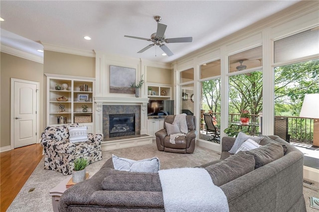 living room featuring a ceiling fan, recessed lighting, ornamental molding, and a fireplace