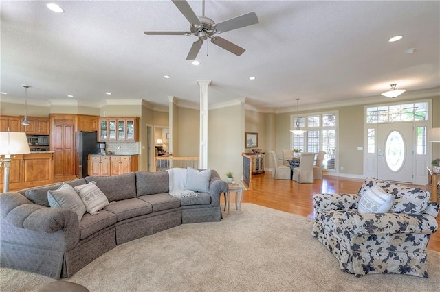living room with recessed lighting, a ceiling fan, ornamental molding, and light wood finished floors