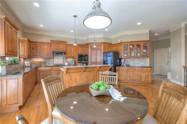 dining room with recessed lighting, ornamental molding, and light wood finished floors