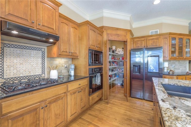 kitchen featuring gas cooktop, built in microwave, stainless steel fridge, under cabinet range hood, and oven