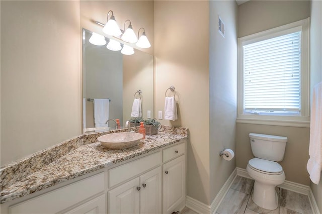 bathroom with vanity, baseboards, toilet, and visible vents