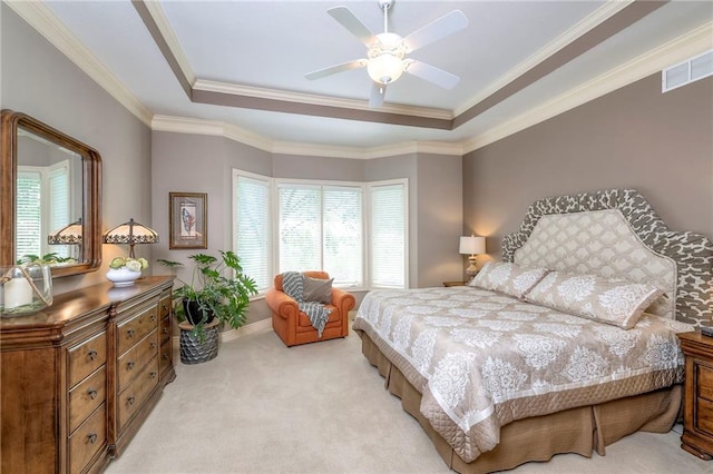 bedroom featuring crown molding, light colored carpet, a ceiling fan, a tray ceiling, and visible vents