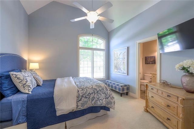 bedroom with a ceiling fan, light colored carpet, high vaulted ceiling, baseboards, and connected bathroom
