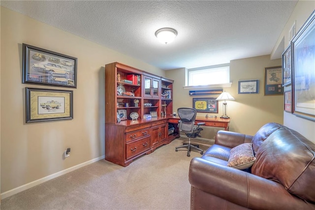 office area with carpet floors, a textured ceiling, and baseboards