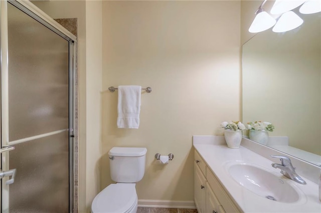 bathroom with vanity, baseboards, toilet, and a shower stall