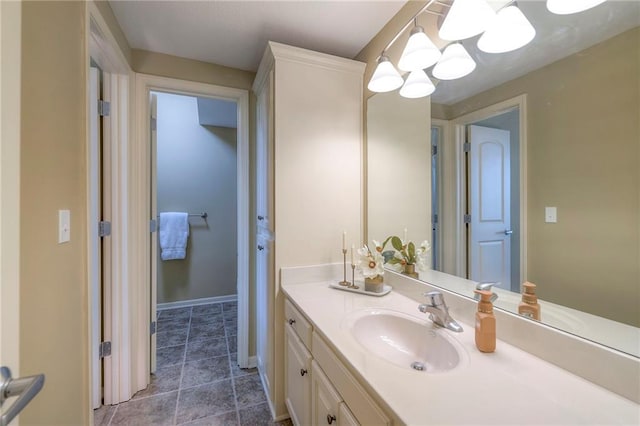 bathroom featuring vanity, baseboards, and an inviting chandelier