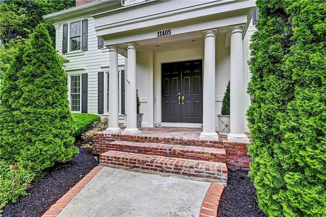 11405 Manor St, Leawood, KS 66211 - view of exterior entry with a porch and a chimney