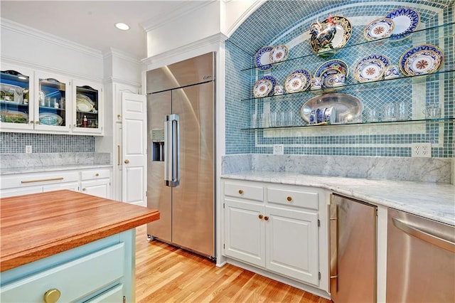 11405 Manor St, Leawood, KS 66211 - kitchen featuring appliances with stainless steel finishes, tasteful backsplash, light wood-type flooring, glass insert cabinets, and white cabinetry