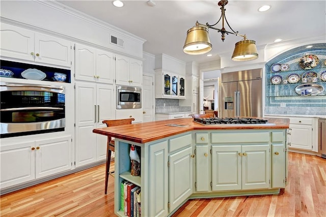 11405 Manor St, Leawood, KS 66211 - kitchen with stainless steel appliances, white cabinetry, a center island, green cabinetry, and light wood-style flooring