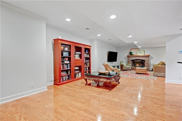 11405 Manor St, Leawood, KS 66211 - living area featuring ornamental molding, wood finished floors, baseboards, recessed lighting, and a brick fireplace
