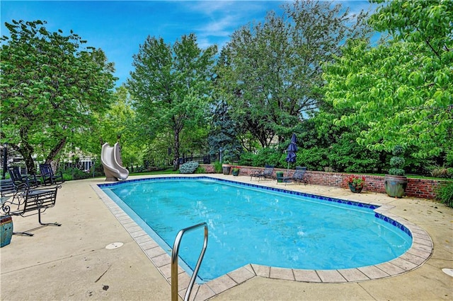 11405 Manor St, Leawood, KS 66211 - view of pool featuring a water slide, a patio area, and view of wooded area