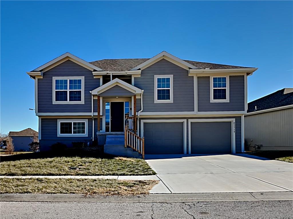 21715 Southcreek Rd, Peculiar, MO 64078 - split foyer home with an attached garage and concrete driveway