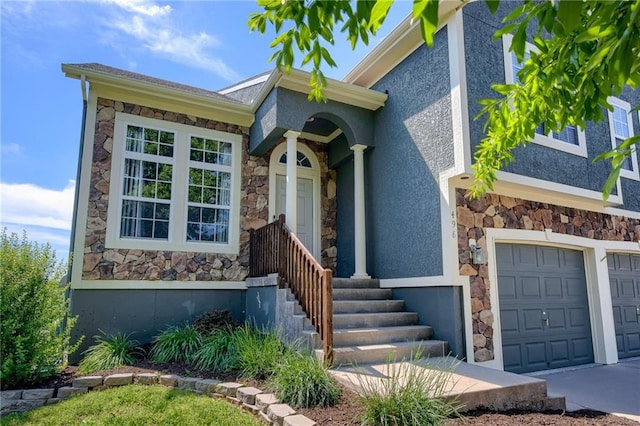 496 S 137th St, Bonner Springs, KS 66012 - view of exterior entry with stone siding, stucco siding, an attached garage, and driveway