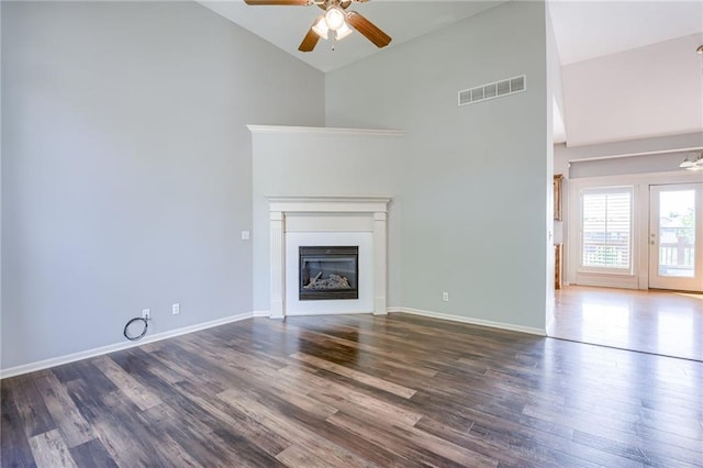 496 S 137th St, Bonner Springs, KS 66012 - unfurnished living room with high vaulted ceiling, a ceiling fan, dark wood-style flooring, a glass covered fireplace, and baseboards